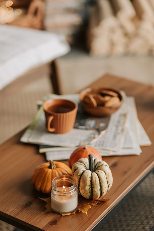 Free Rustic autumn setup with pumpkins, candle, and coffee inside home. Stock Photo