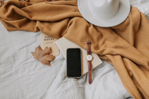 A Mobile Phone beside a Wristwatch