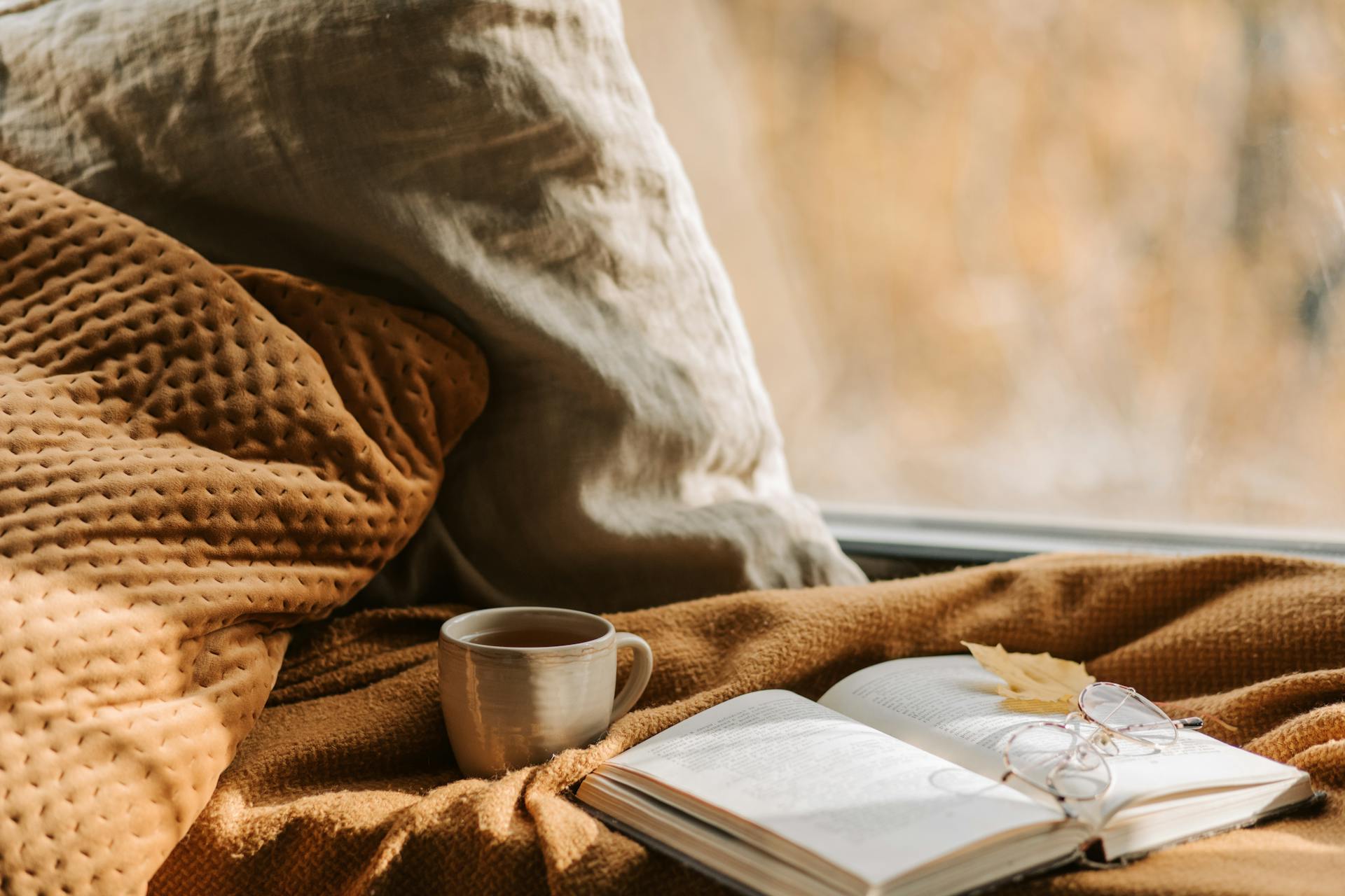 Une tasse de thé à côté d'un livre ouvert