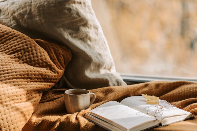 A Teacup Beside An Open Book