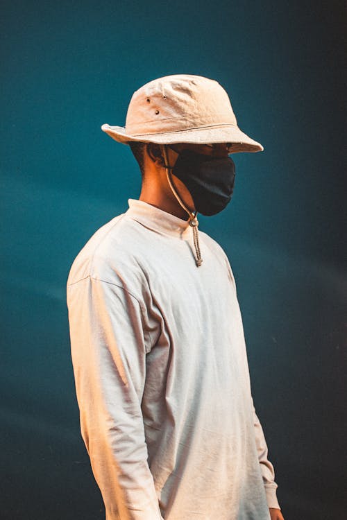 A Man Wearing a Black Mask and a Beige Bucket Hat · Free Stock Photo