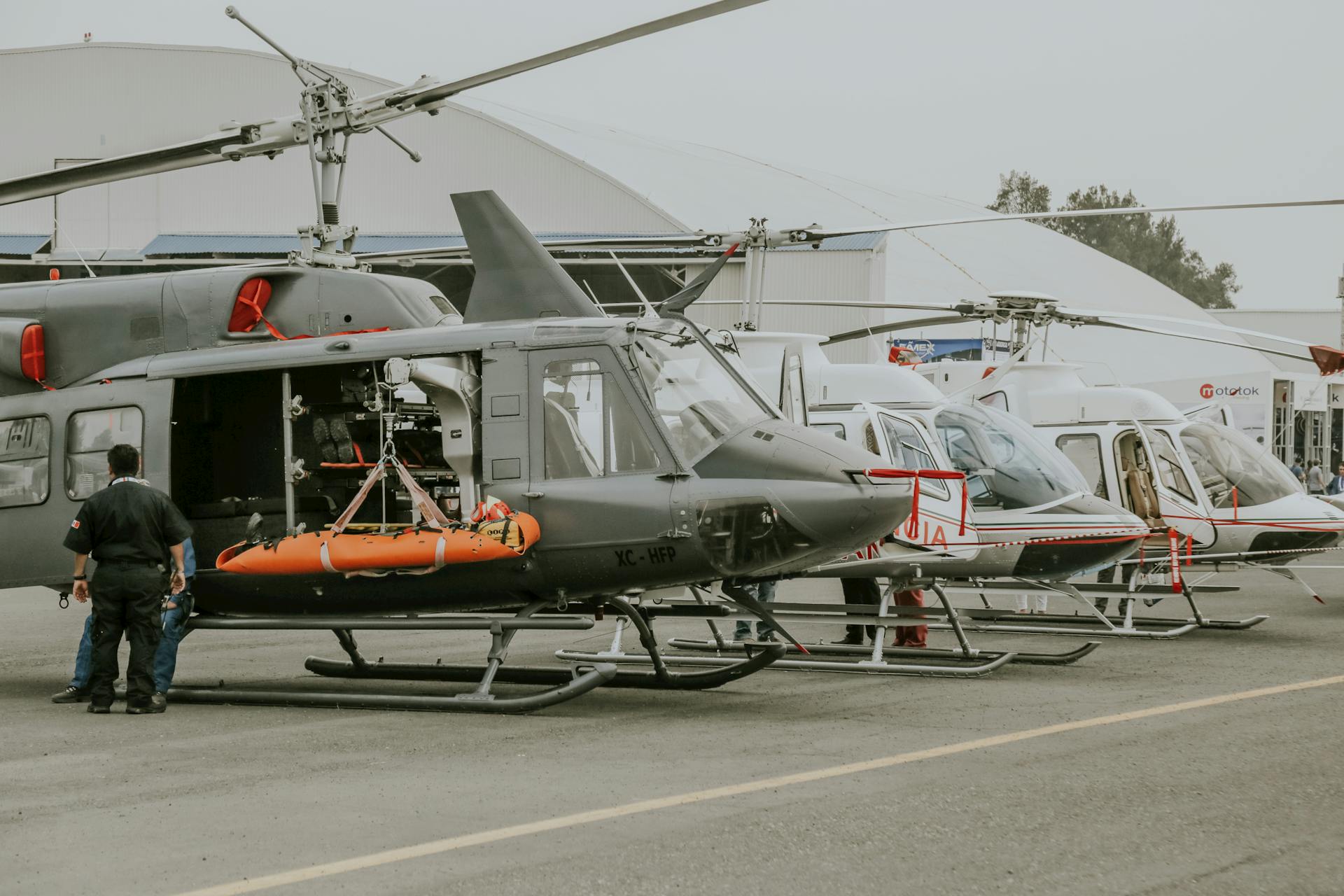 Helicopters displayed at an outdoor airshow with visible equipment and personnel.