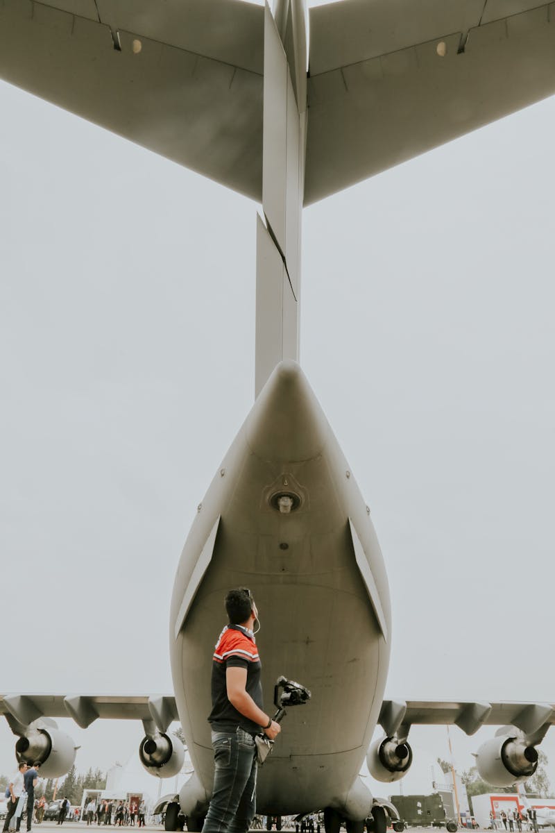 Man Standing behind Airplane