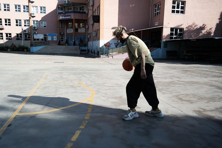 A Man Playing Basketball Alone