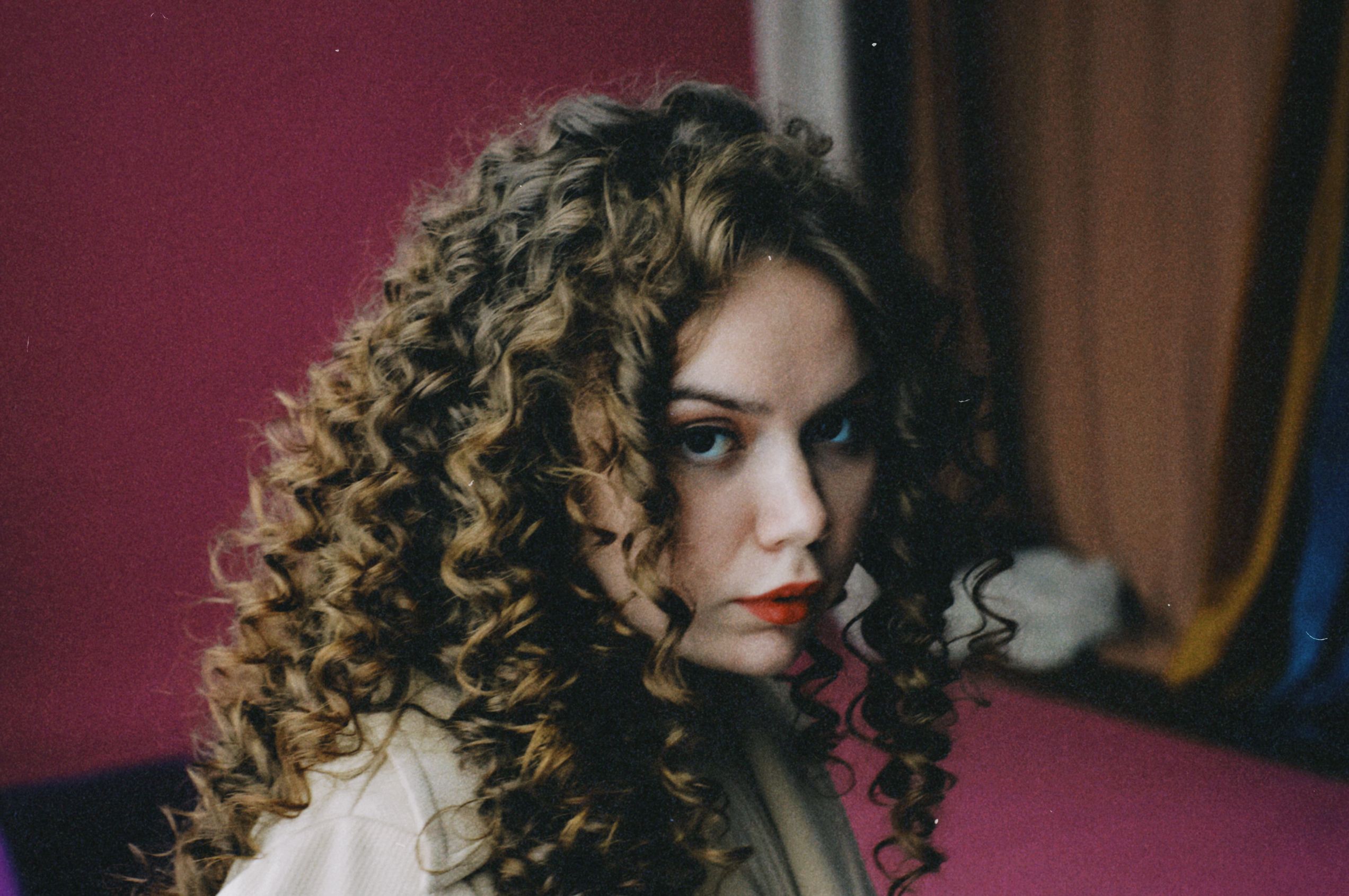 Portrait of a Beautiful Woman with Brown Curly Hair · Free Stock Photo