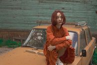 Young Woman with Red Hair Sitting on Car Mask