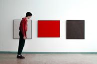 Man Standing Tilted and Looking at Modern Art Pictures 