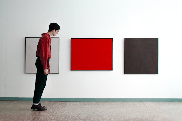 Man Standing Tilted And Looking At Modern Art Pictures 