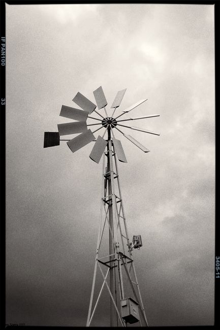 Monochrome image of a vintage windmill in Gramalote, Colombia, under a dramatic sky.