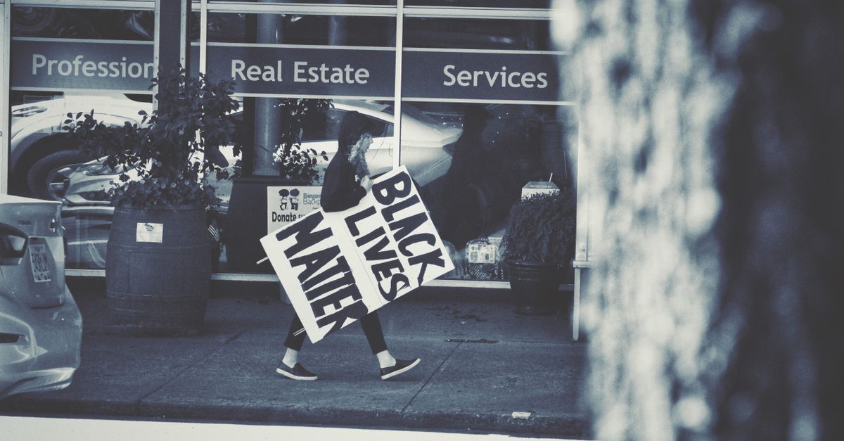 Protester with a Black Lives Matter sign walking on Newberg street.