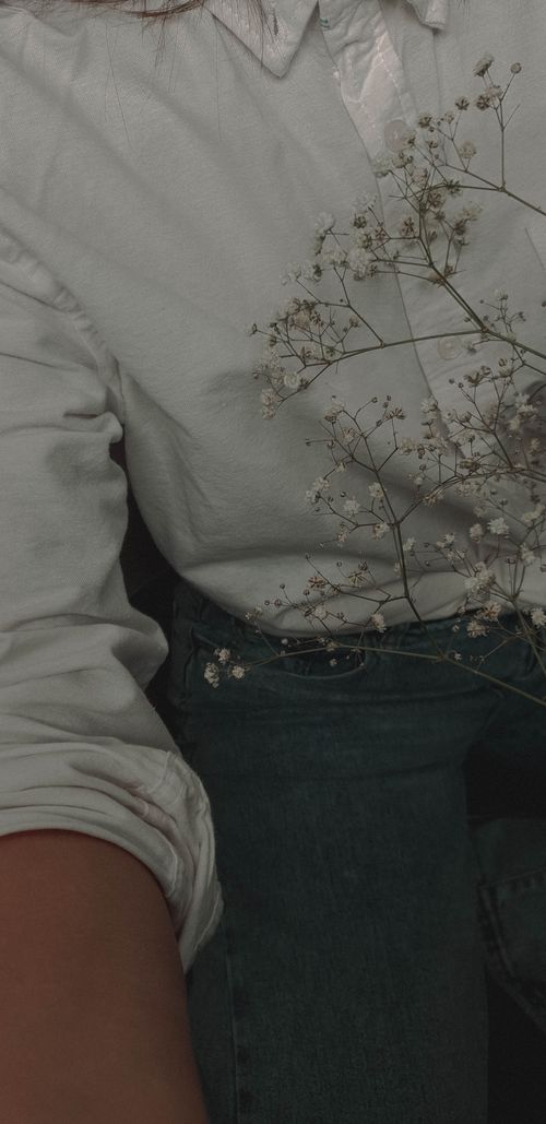 Free A stylish close-up of baby's breath flowers paired with casual denim and a white shirt. Stock Photo