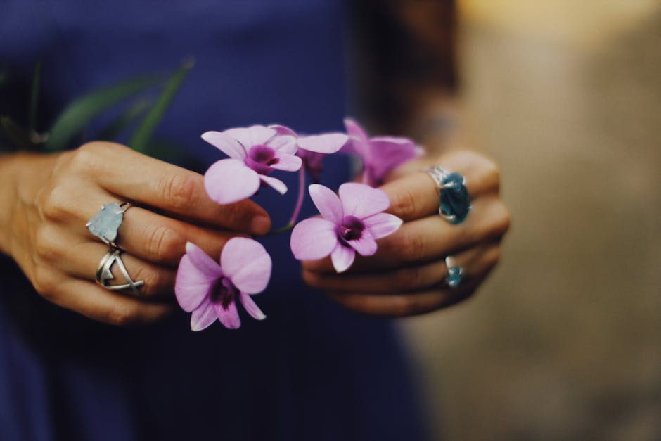 A close-up of beautiful almond-shaped nails with a delicate floral design, showcasing a popular spring nail trend.