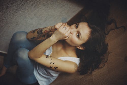 Woman with Arm Tattoo Lying on the Floor