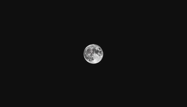 A striking full moon shining brightly against a dark night sky.