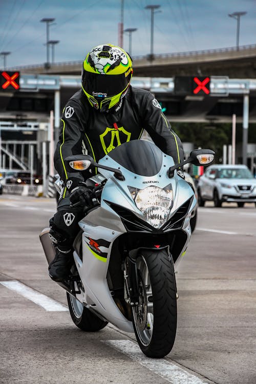 Free Man Wearing a Green Helmet Riding a Motorcycle Stock Photo