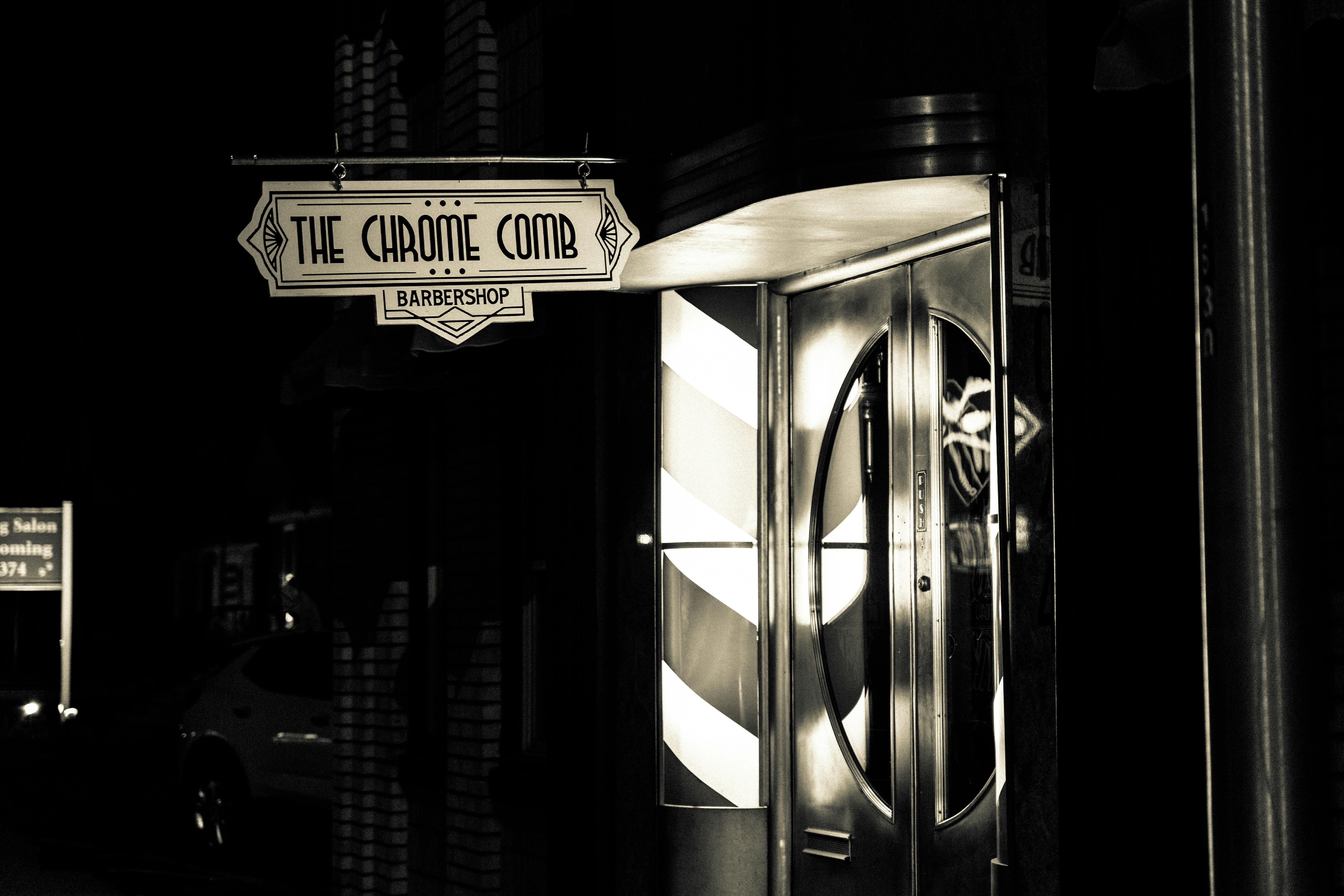 Free Vintage art deco barbershop entrance captured in monochrome at night. Stock Photo