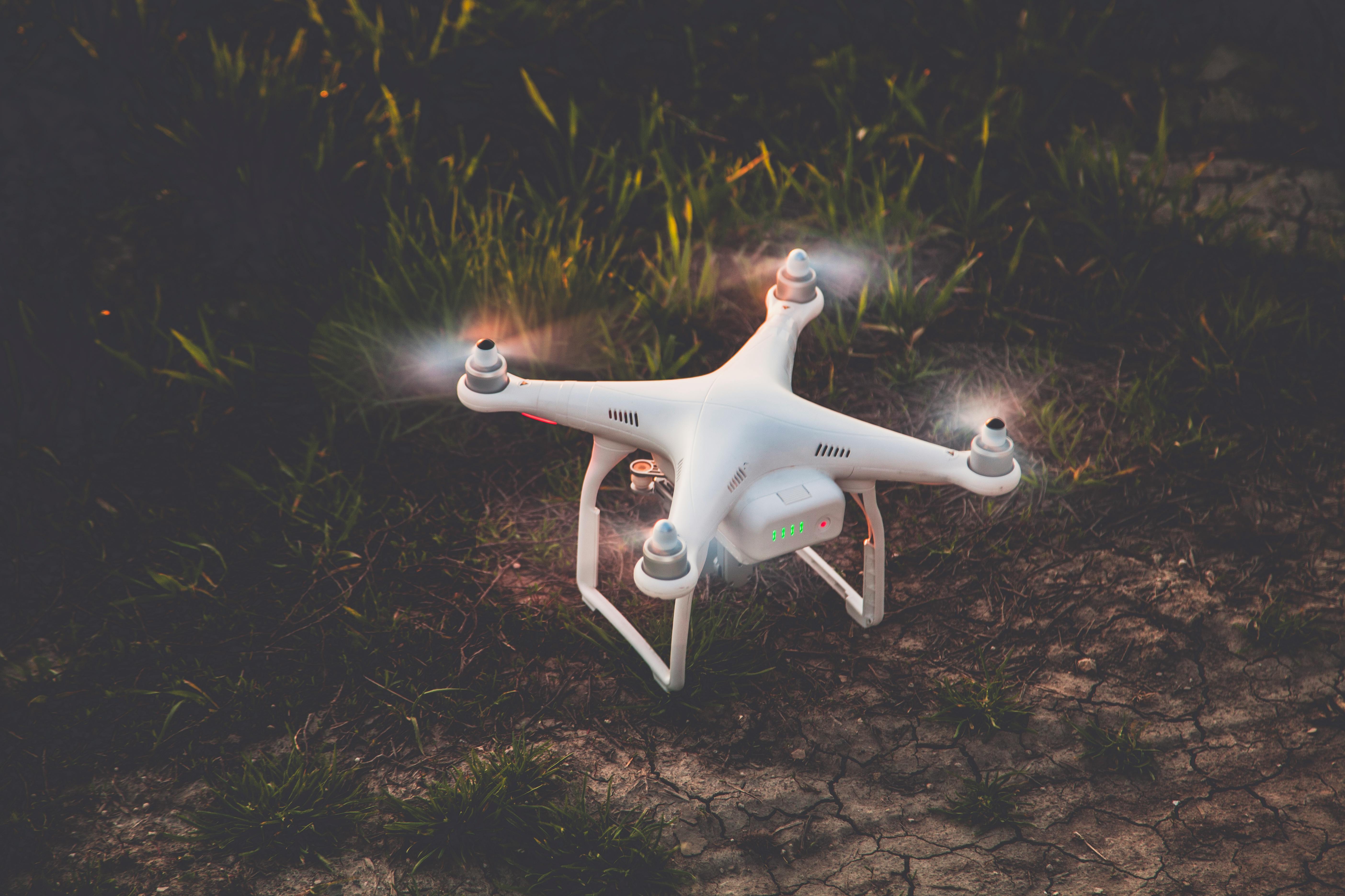 best drone for beginners with camera uk - A white drone resting on grassland at twilight, perfect for aerial photography needs.