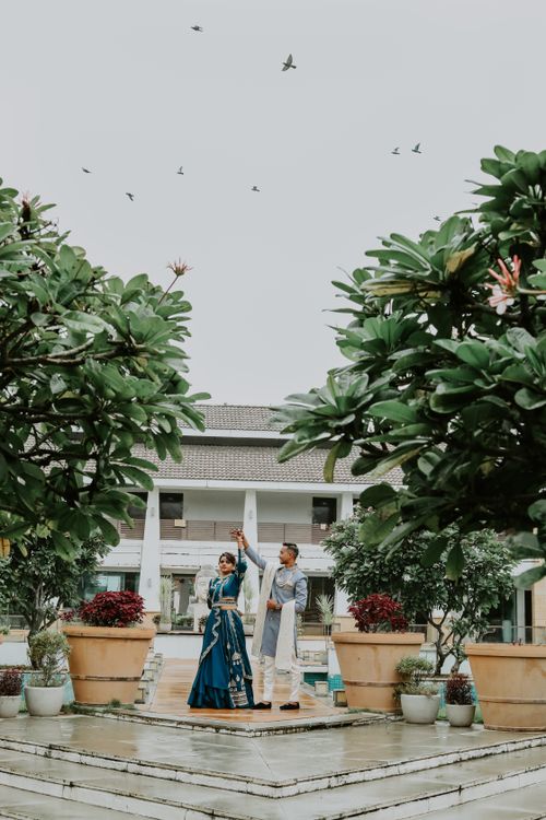 Free A couple romantically dances in a lush garden, surrounded by nature and elegance. Stock Photo