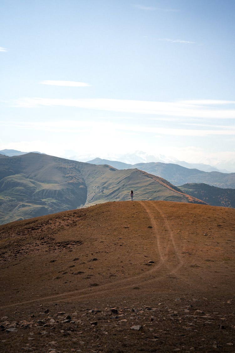 Person Standing On Mountain Top