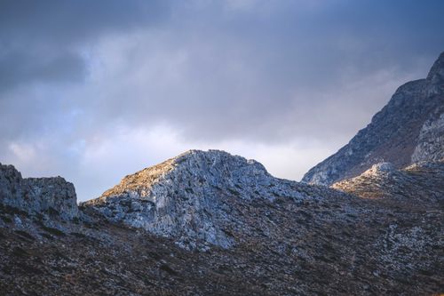 Free Scenic view of rugged mountain peaks under an overcast sky with dramatic lighting. Stock Photo