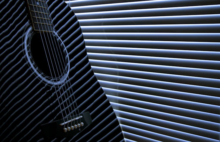 Close Up Photo Of Acoustic Guitar Near Blinds