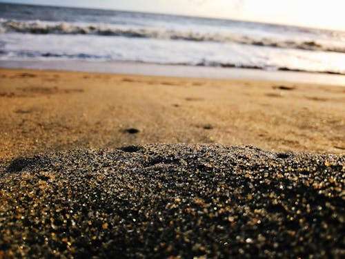 Free Low-angle Photography of Sand Near Body of Water Stock Photo