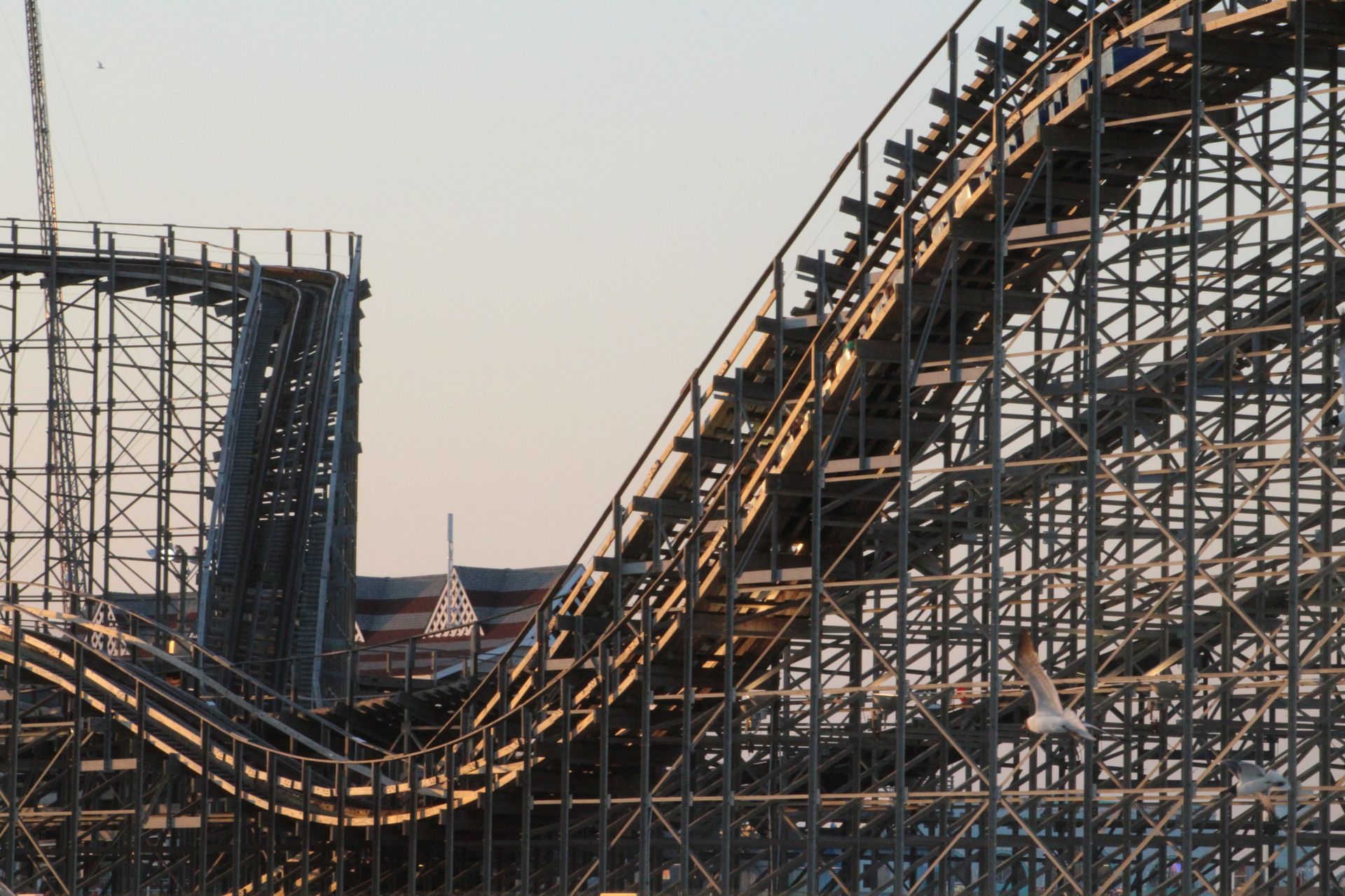 Gün batımında bir lunaparkta tarihi ahşap roller coaster