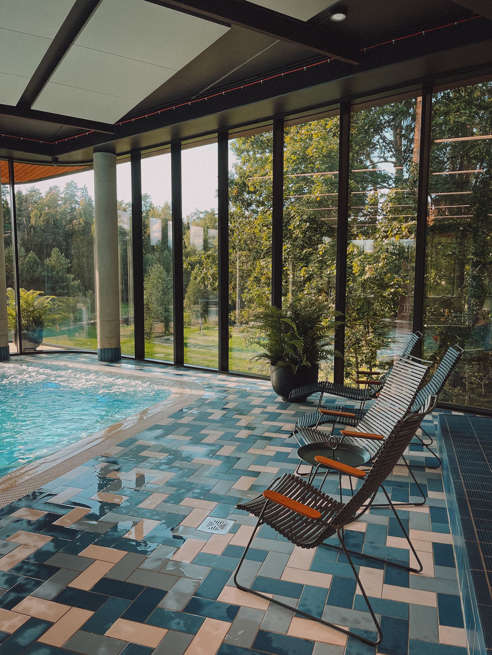 Lounge chairs beside a garden-facing pool