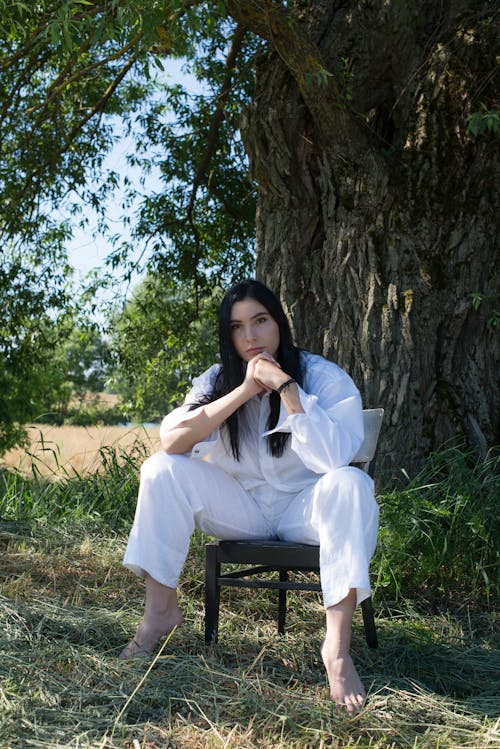 Woman in White Clothes Posing with Her Hands Together