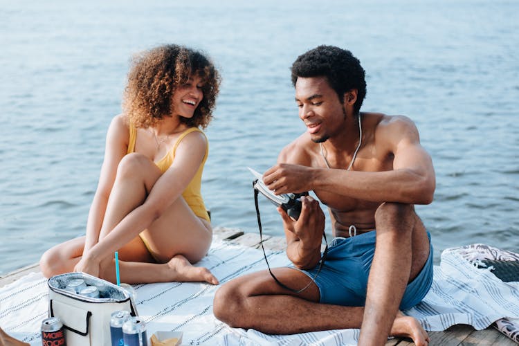 Portrait Of Man And Woman Looking At Photo At Lake