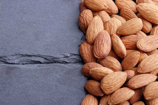 Close-up of raw almonds on a slate surface, showcasing their healthy, organic nature.
