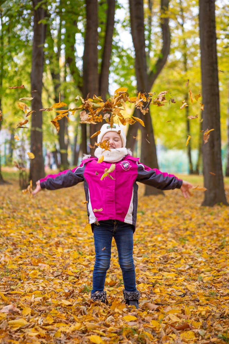 Child Playing With Autumn Leaves