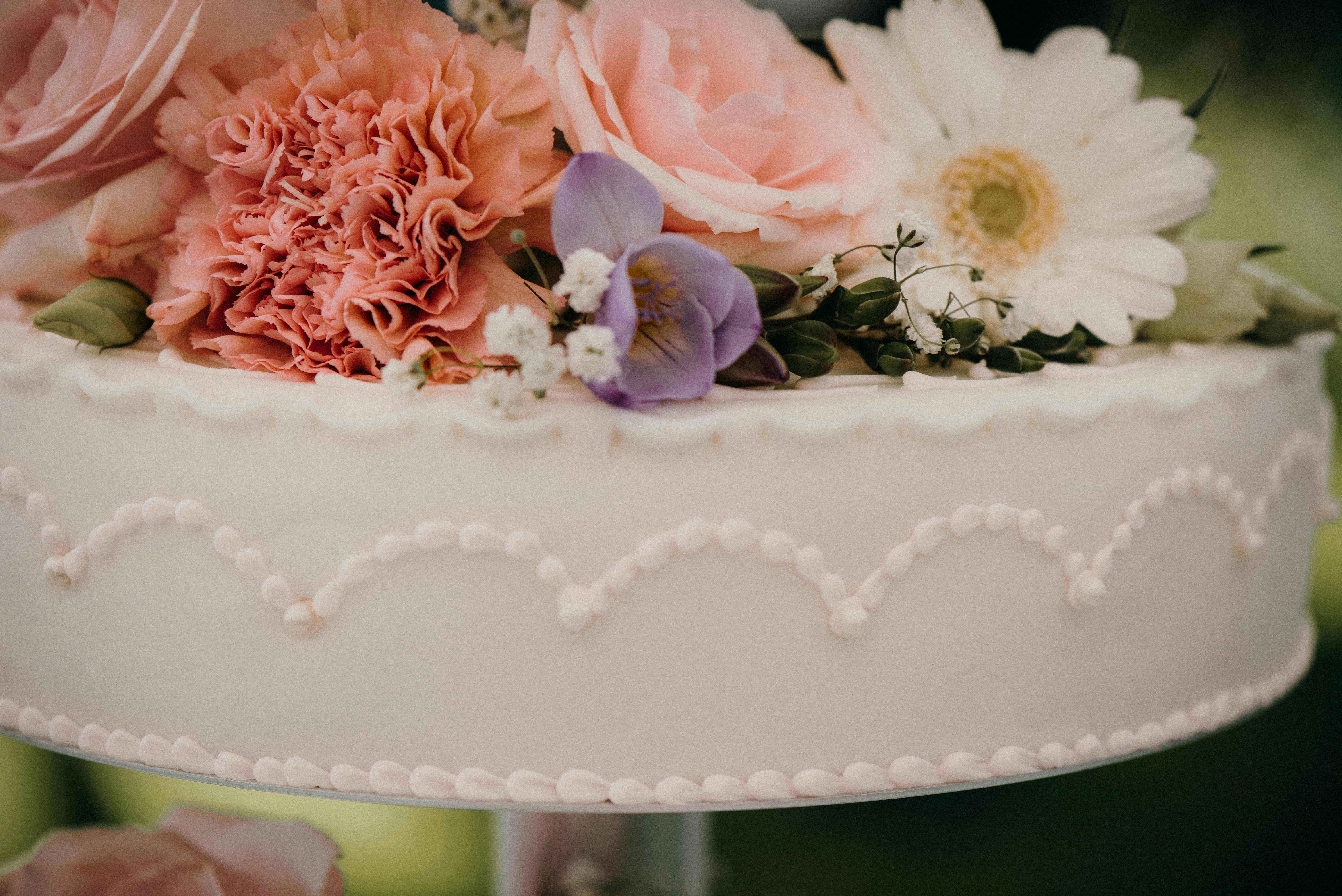 Close-up of a beautifully decorated wedding cake with fresh flowers.