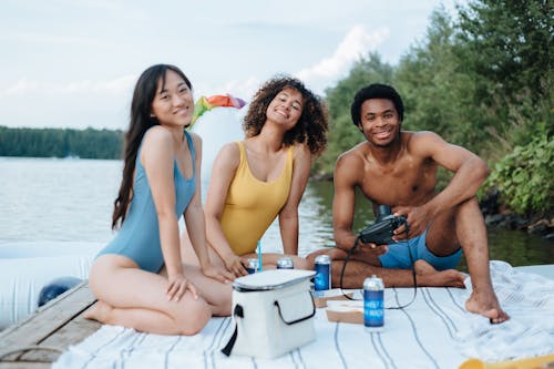 People Wearing Swimwear Sitting on a Deck