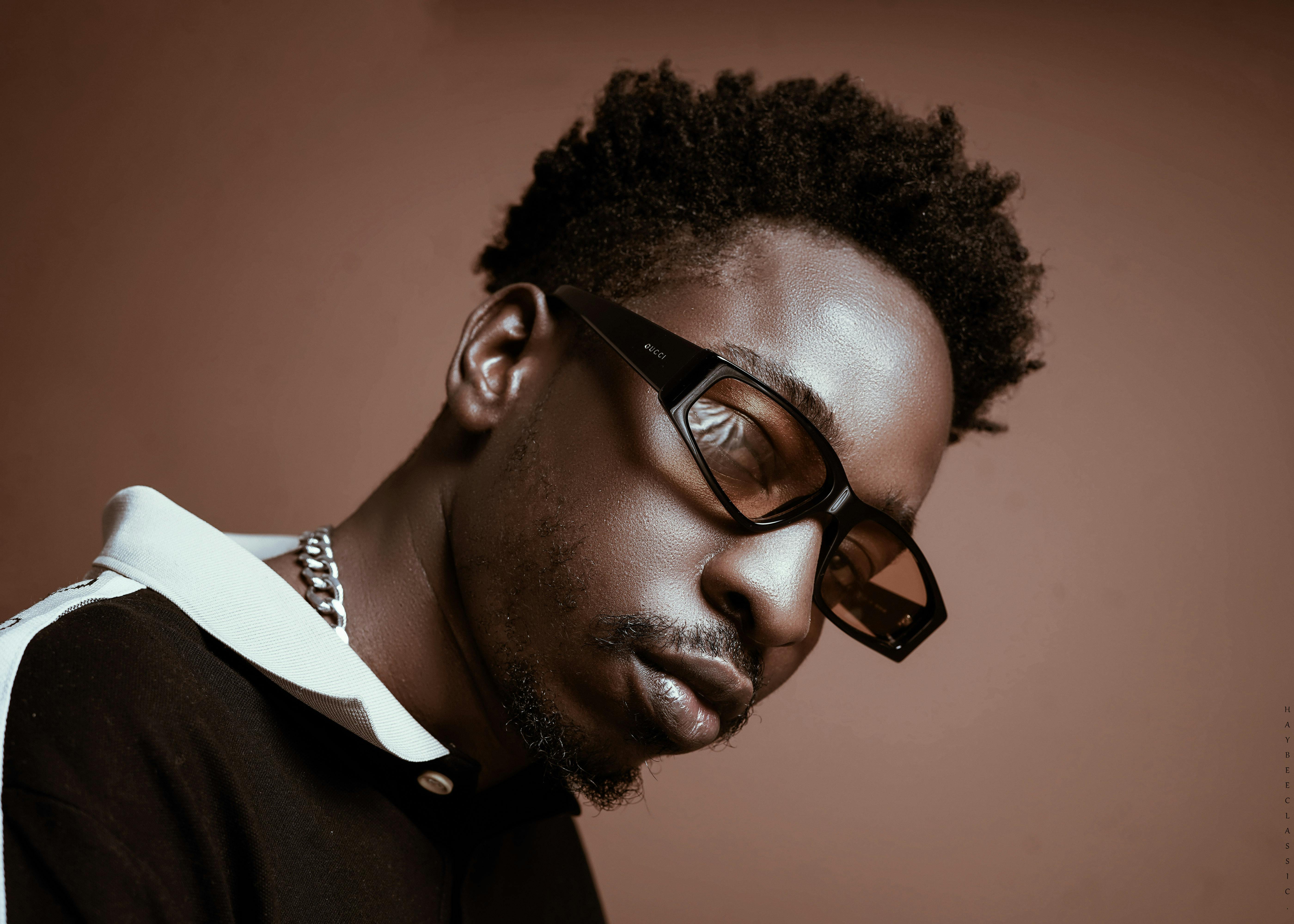 Close-up of a man with sunglasses in a modern studio setting.