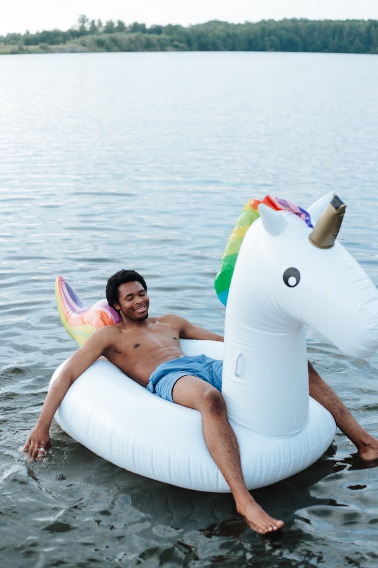 Man Lying In Unicorn Pool Float