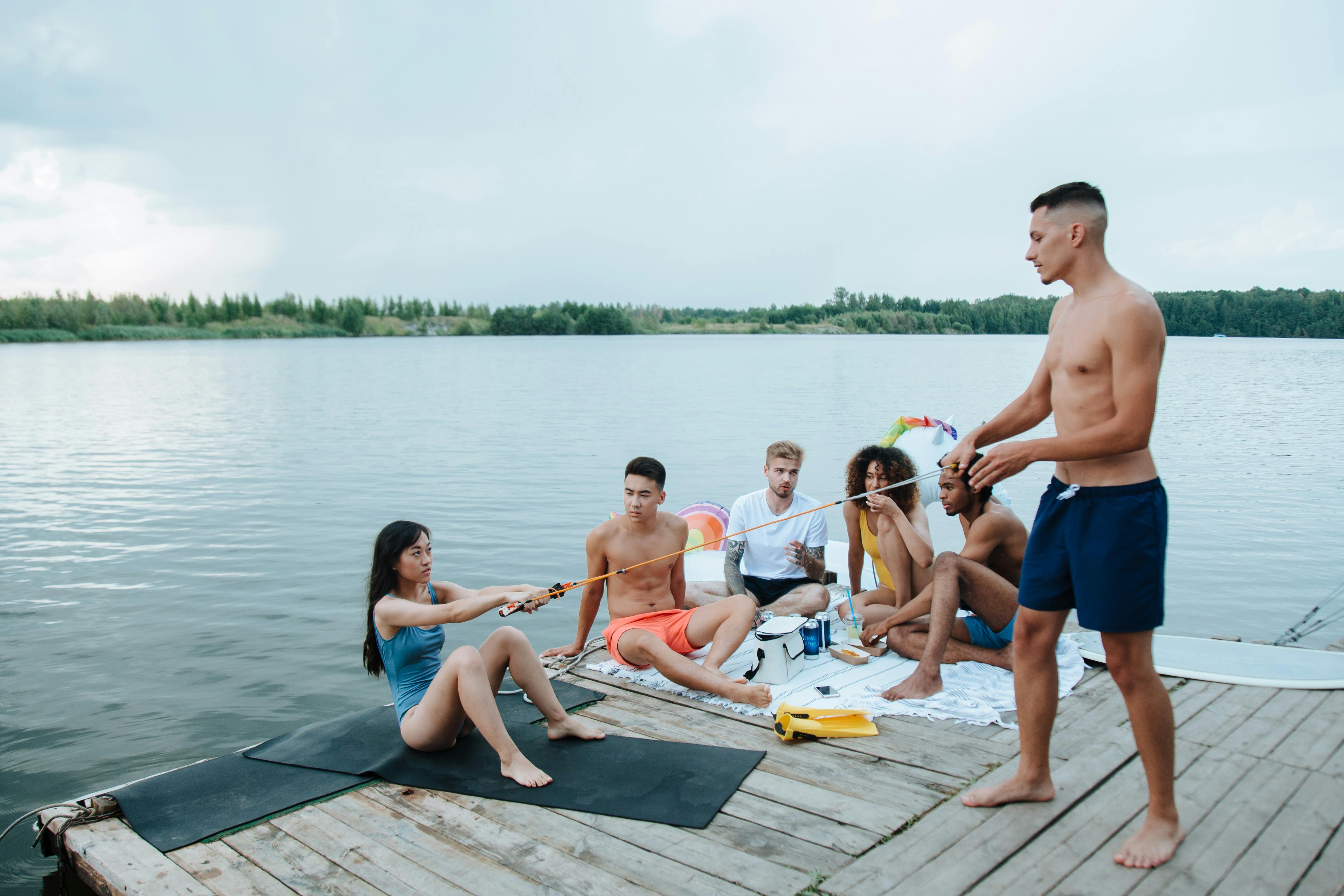 group of friends hanging out together near the lake