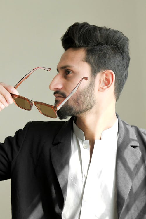 Man Holding Brown Framed Sunglasses With Black Suit