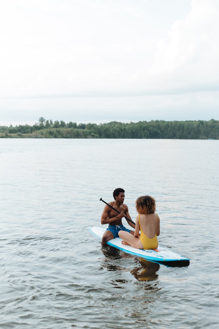 Couple On Paddleboard On Lake 