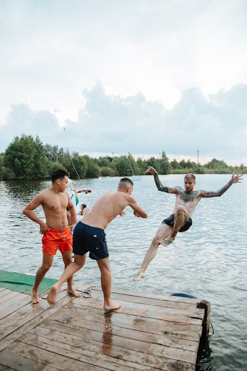 Young Men Jumping Into Lake 