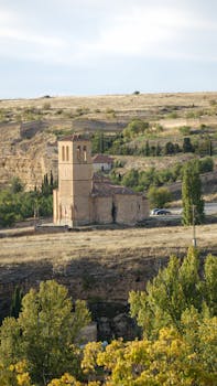 Scenic view of a historic church in Segovia, Spain, surrounded by nature.