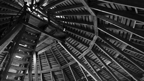 グレースケール写真の茶色の木製の天井