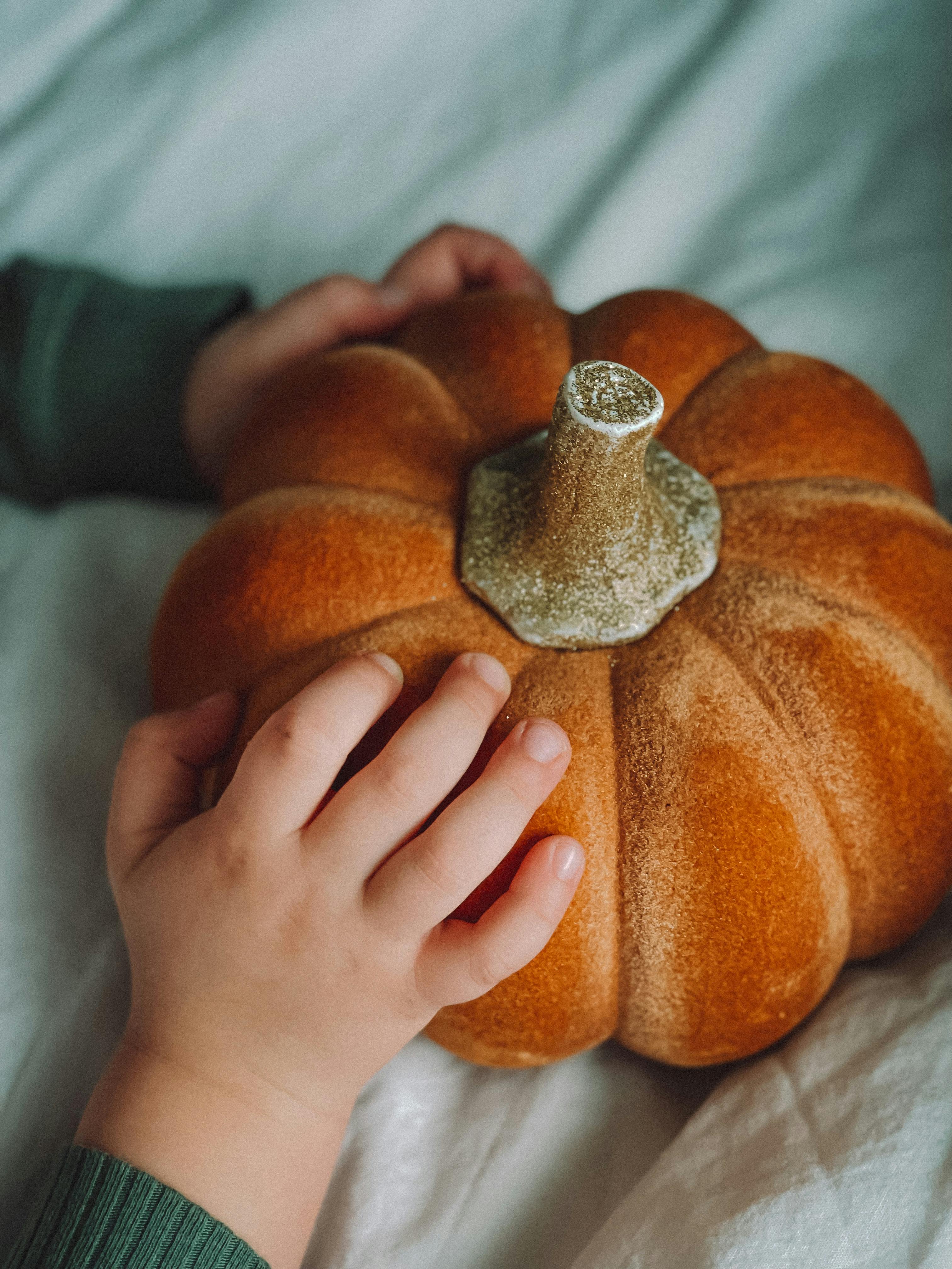 close up view of kid hands on pumpkin