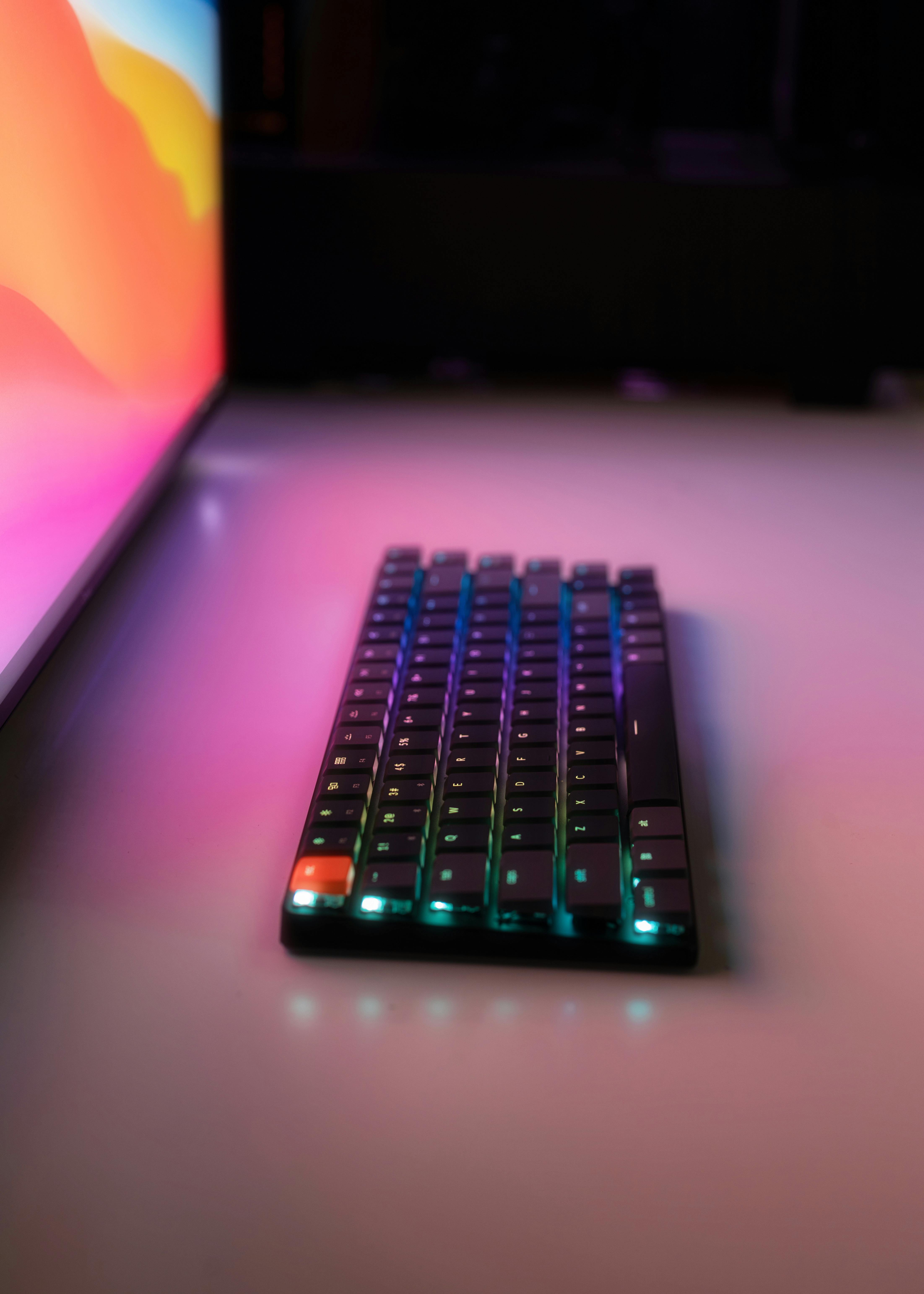 pc keyboard illuminated by screen glowing pink safari wallpaper