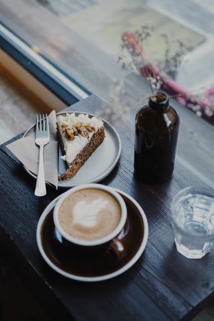 Inviting cafe setting with coffee and cake by a window, perfect for a cozy moment.