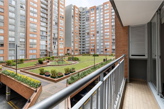 A view of a modern apartment complex from a balcony overlooking a playground area.