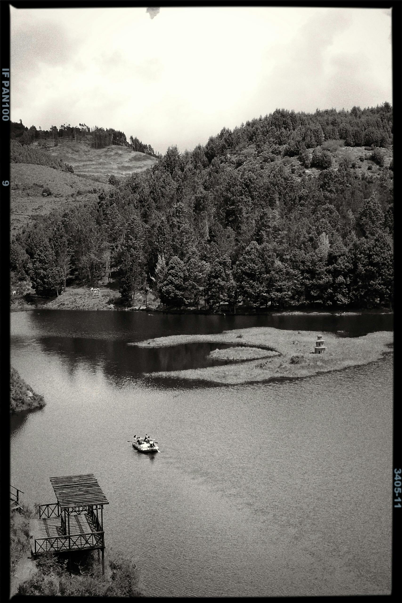 Aerial view of a serene lake surrounded by lush forests in Cácota, Colombia.