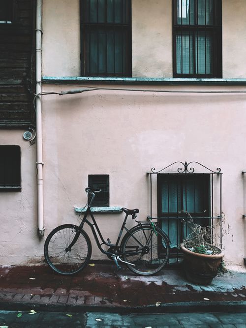 Free A classic bicycle leaning on an urban building wall, creating a vintage city vibe. Stock Photo