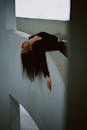 Woman Hanging Over Concrete Wall