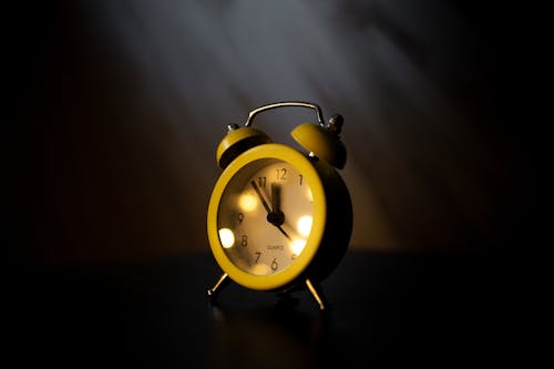 Free Yellow Alarm Clock on the Dark  Stock Photo
